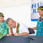 Acting Foreign Minister and Finance Minister David Paul signs the South Pacific Nuclear Free Zone Treaty March 3 during the Nuclear Victims Remembrance Day event in Majuro. Watching are President Hilda Heine, left, and survivors of the Bravo hydrogen bomb test in 1954. Photo: Chewy Lin.