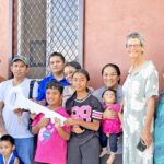 An elated John Zedkaia, fourth from left, and his family receive the key to their two-story house. With them is USDA Rural Development head Zed Zedkaia and MIDB Managing Director Dwight Heine, at left, and US Ambassador Laura Stone, family members and USDA/MIDB representatives. Photo: Wilmer Joel.