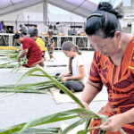 Marshallese girls and women compete in the “enrã” (basket) weaving competition as part of Robert Reimers Enterprises 75th anniversary celebration. Photo: Eve Burns.