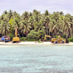 Heavy equipment for the Pacific International Inc. boat channel work line the beach at Bikarej Island, Arno Atoll.