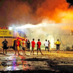 As bystanders and firefighters look on, the Amata Kabua International Airport fire truck — the only working fire truck in the capital city — shoots water into the Nitijela inferno in the early morning hours Tuesday. Photo: Chewy Lin.