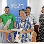 IOM head of office Hilary Vanderwey, left, joined with Japan Ambassador Hirohisa Samo to sign an agreement to support food security efforts in two atolls. They were joined by Foreign Minister Kalani Kaneko, second from left standing, and other RMI and IOM officials. Photo: Rubon JR Jacklick.