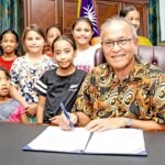 President David Kabua shown in his office joined by a team of children during a ceremony highlighting advocacy for children and youth. Photo: Chewy Lin.