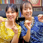 Recently departed Japan International Cooperation Agency Volunteer math teachers Nana Miyazaki, left, and Chikako Kato sign “100,” promoting the “100% Goal Math Test” conducted earlier this year in Majuro public elementary schools. Photo: Giff Johnson.